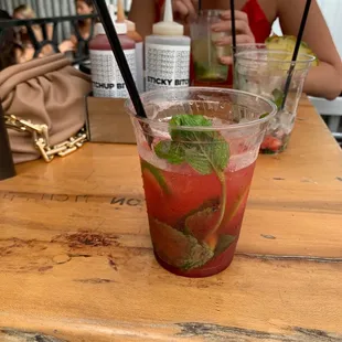 a woman sitting at a table with a drink