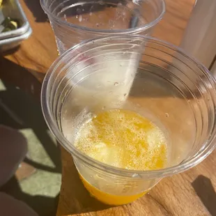 two plastic cups filled with orange juice