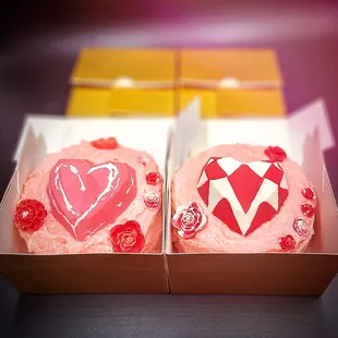 two decorated cupcakes in a box