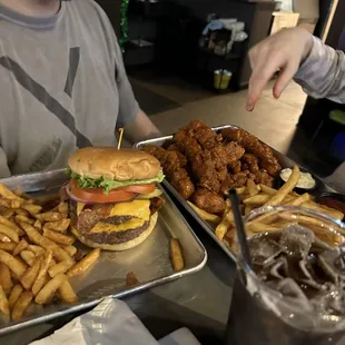 a man sitting at a table with two trays of food