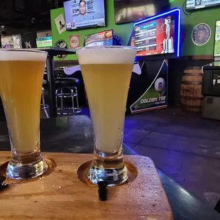 two glasses of beer on a cutting board