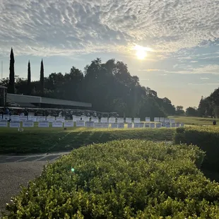 a view of the sun setting behind a fence