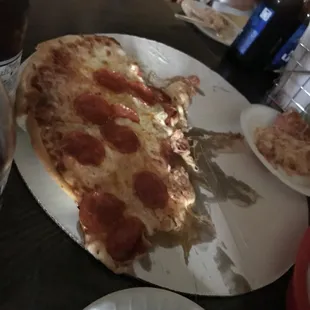 a slice of pepperoni pizza on a paper plate