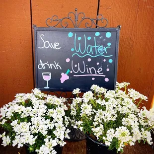 two buckets of flowers and a chalk board