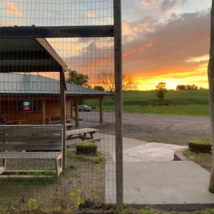 a view of a sunset through a fence