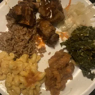 Oxtails, rice, cabbage, greens, candied yams and Mac and cheese