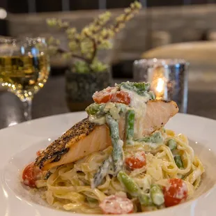 a plate of pasta with salmon and vegetables