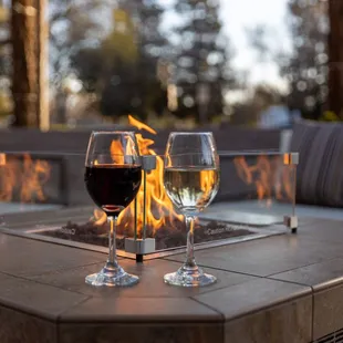 two glasses of wine on a fire pit