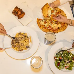 a group of people eating pizza and salad