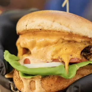 a hand holding a cheeseburger