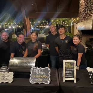 a group of people standing behind a table