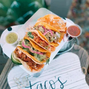 tacos on a tray with sauces