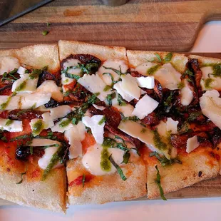 a flatbread pizza on a cutting board