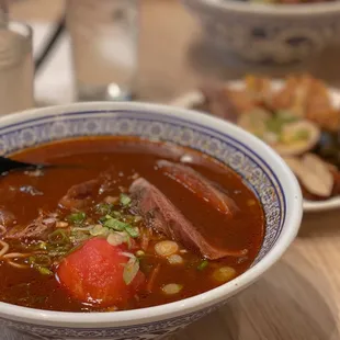 a bowl of soup with meat and vegetables