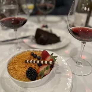 a bowl of dessert and a glass of wine