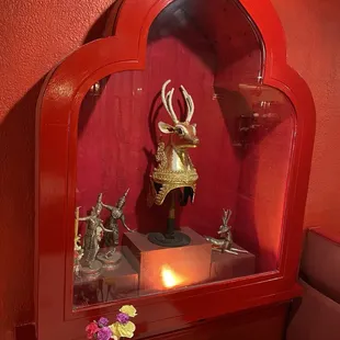 a red wall with a gold deer statue
