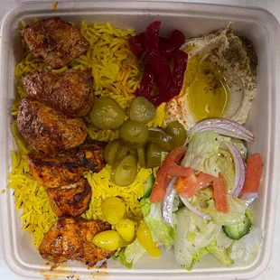 Chicken Kabob plate with rice, salad and hummus.