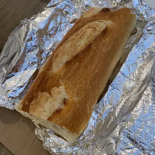 a sandwich wrapped in aluminum foil