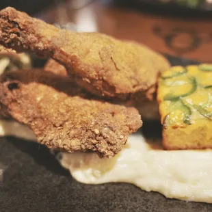 Fabled Fried Chicken. Thick battered chicken with spectacular jalapeño cheddar cornbread, potato purée, and smoked bacon collard greens.