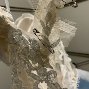 Bunched up mesh/appliqué from hem that should not have been, nor was discussed placing anywhere on side of dress or on straps