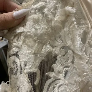 More appliqué installed at the side of dress without reason or consent. requested was a hem, bustle &amp; sleeve. This is at my rib cage. Why