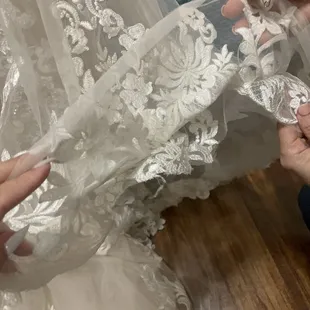 Sloppy hem. 3 different seamstress' confirmed trash work done to designer gown. "Woman should not touch wedding dresses."