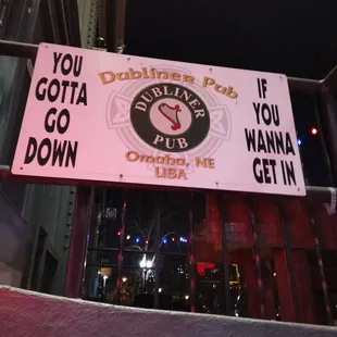 Sign out front marking the entrance (go down the stairs!)