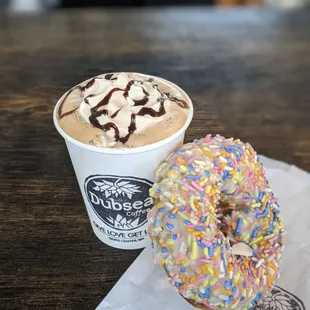 a cup of coffee and a sprinkled donut