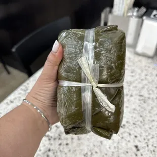 a person holding a wrap of sushi