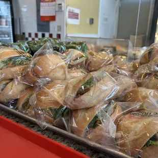 a tray of sandwiches wrapped in plastic