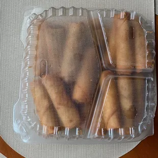 a plastic container with four cookies in it