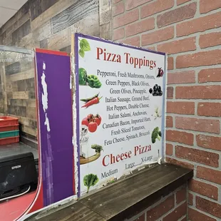 a pizza toppings sign on a shelf