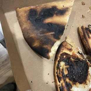a burnt pizza in a box