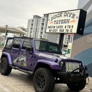 a purple jeep parked in front of a building
