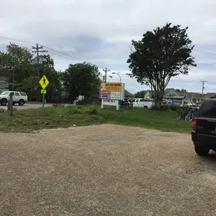 a parking lot with a sign and a car