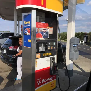 a woman filling up her car at a gas station