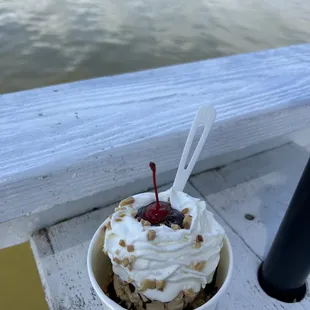 a cup of ice cream with a cherry on top