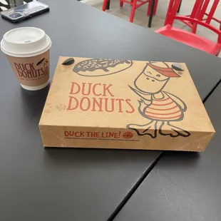 a cup of coffee and a box of donuts