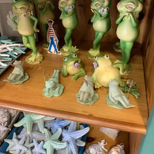 a shelf full of frog figurines