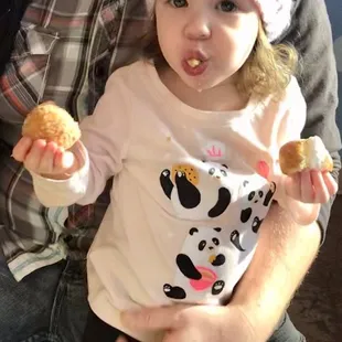 Party guest enjoying Cinnamon Crumb Donut Hole and Maple Bar Donut with Whip Cream and Teddy Grahams on top !