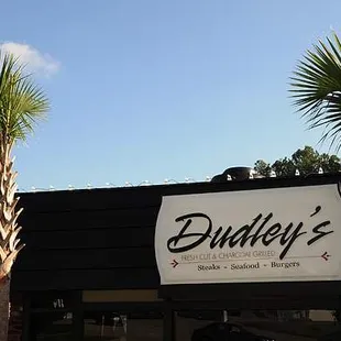 the outside of a restaurant with palm trees