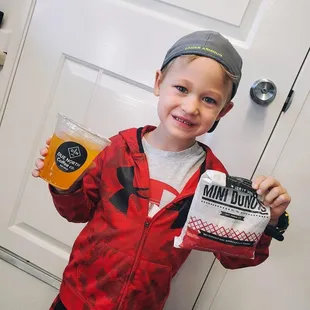 a young boy holding a cup of coffee
