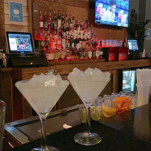 two martini glasses on a bar