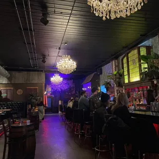 people sitting at a bar with chandeliers