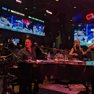 a man and a woman sitting at a piano