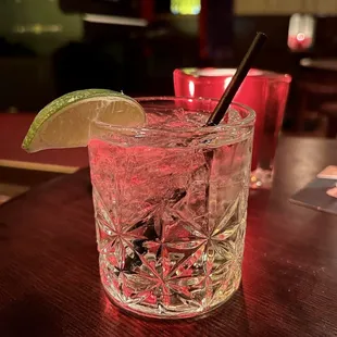 a gin cocktail with a lime wedge