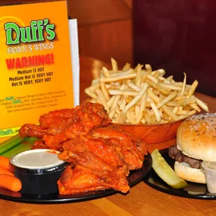 a plate of chicken wings and a bowl of fries