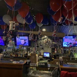 a bar with balloons and televisions