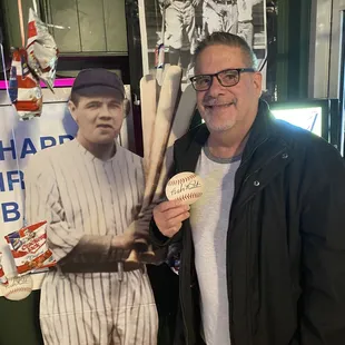 a man holding a baseball and a baseball bat