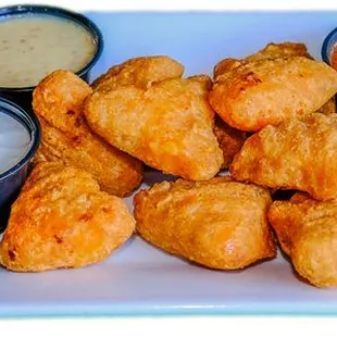 a plate of chicken wings with dipping sauces